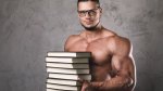 Muscular man wearing glasses and holding a stack of books for continuing education for fitness professionals